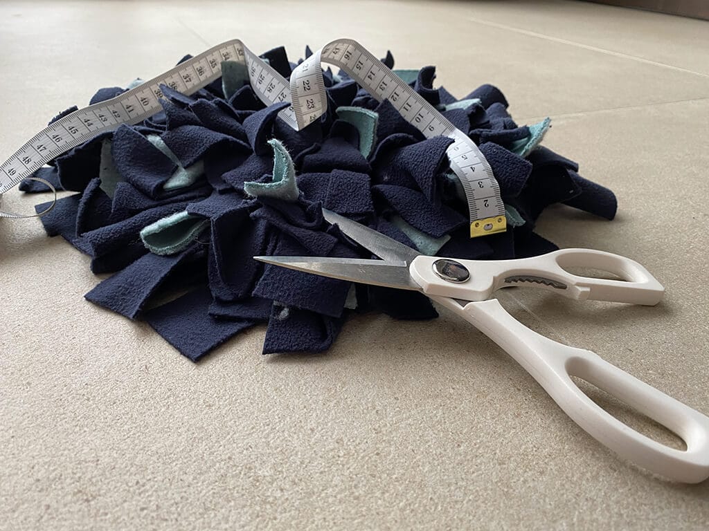 Schnüffelteppich mit Schere und Maßband
